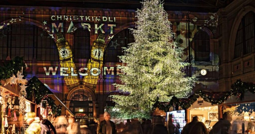 a large building with a large tree with lights